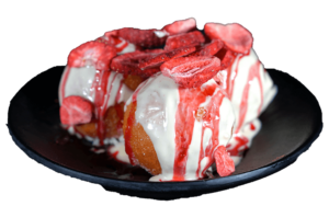 Quarkbällchen mit weißer Schokolade, Erdbeersoße und Erdbeeren auf schwarzem Teller