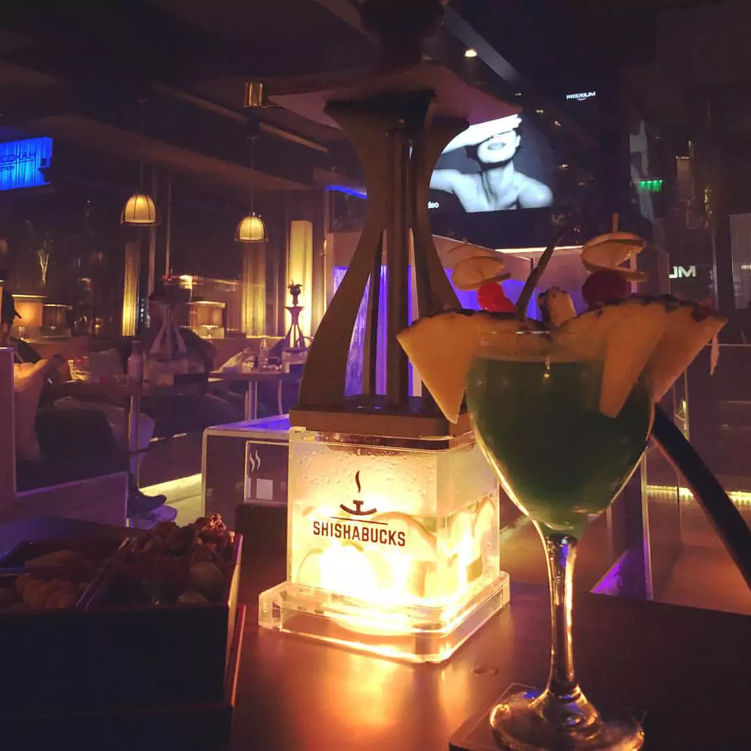 Eine leuchtende Shishabucks Shisha und ein dekorierter Cocktail in einer gemütlichen Shisha Lounge an der Alster.