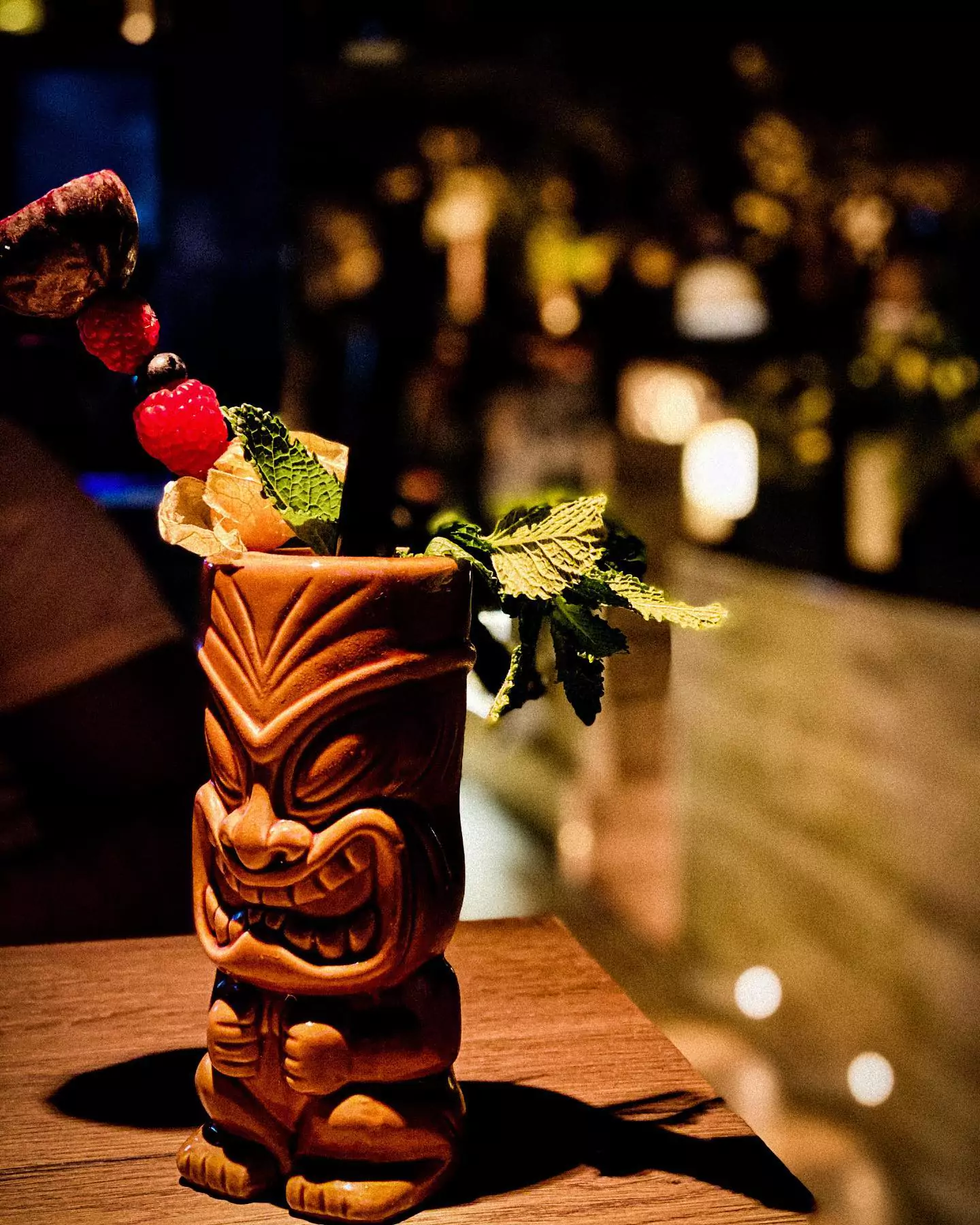 Ein exotisch dekorierter Cocktail in einem Tiki-Becher mit frischen Früchten und Minzblättern, serviert in einer Shisha Bar in Barmbek, Hamburg.