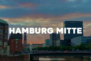 Abendliche Skyline von Hamburg Mitte, mit modernen und historischen Gebäuden entlang eines Kanals.