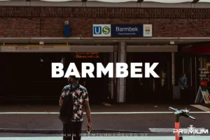 Ein Mann betritt die U-Bahn-Station Barmbek in Hamburg, nahe der lokalen Shisha Bar Barmbek, überlagert von großem Text „BARMBEK“ und der Webadresse.